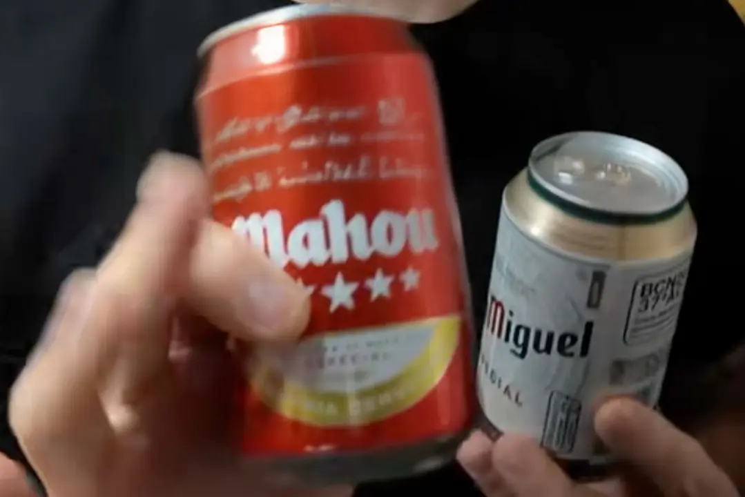 Llaunes de cervesa Mahou verdes i roges sobre una taula de bar. Tiktok @cervecero_miguel