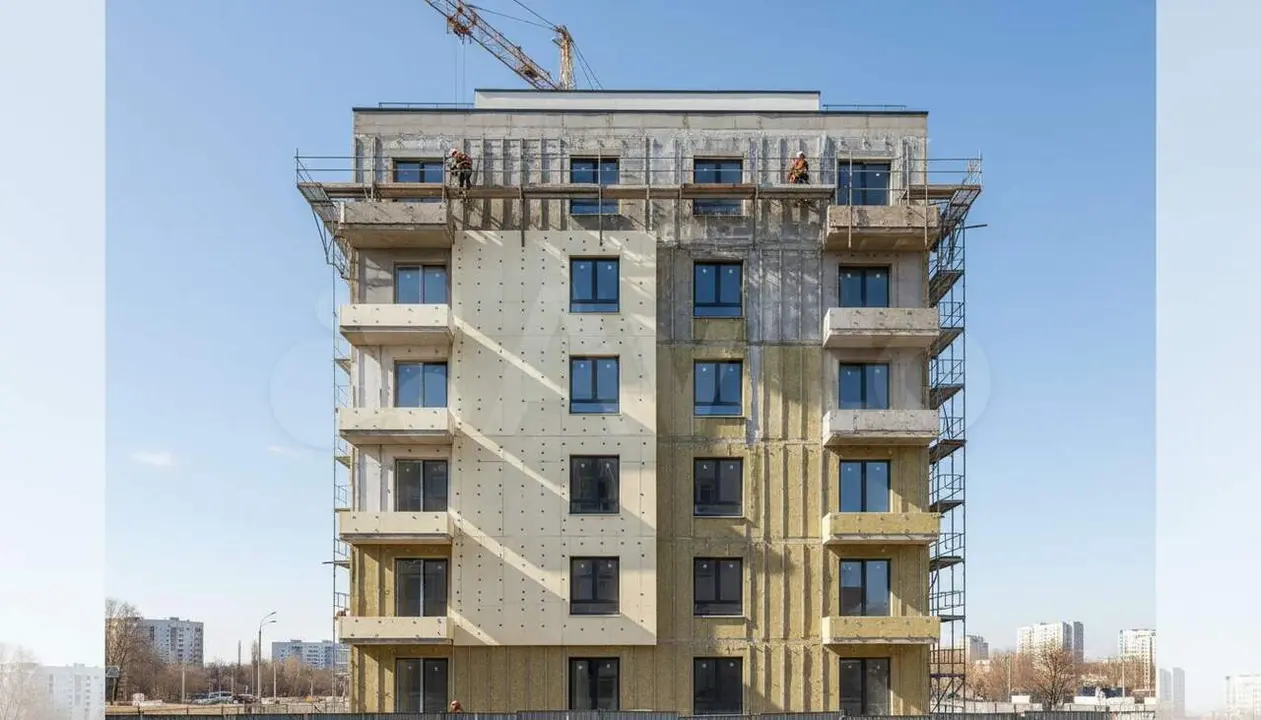 Fa&ccedil;ana d'edifici residencial amb a&iuml;llament t&egrave;rmic exterior sota un cel blau clar