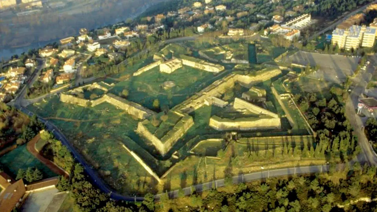 Vista a&egrave;ria del castell de Montju&iuml;c de Girona, on s'aprecia el per&iacute;metre de l'antic fort&iacute;. Foto de Jordi S. Carrera, millorada amb IA.