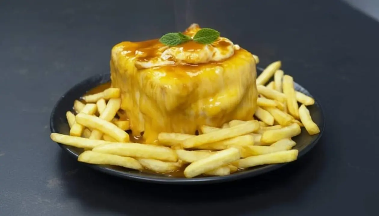 Francesinha tradicional portuguesa amb formatge fos i salsa especial servida en un plat gran per degustar &mdash; Imagen generada por IA