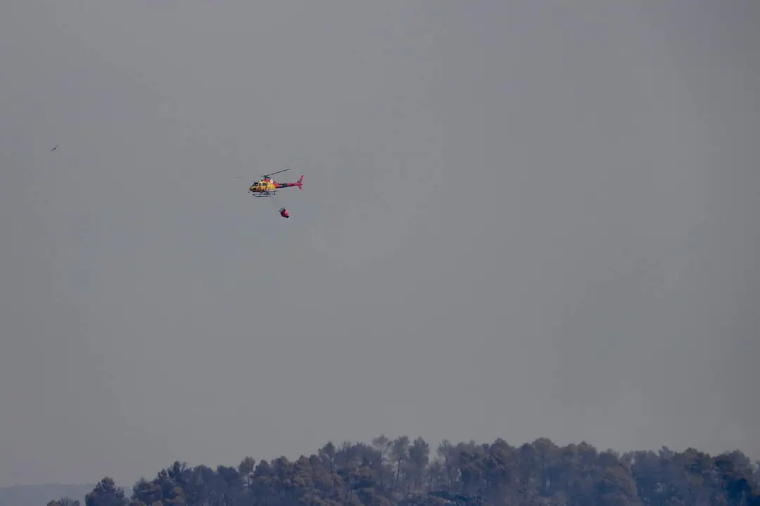 Dotacions de bombers treballant intensament per controlar l'incendi de Sentmenat amb urbanitzacions desconfinades al fons &mdash; Imagen de la Fuente