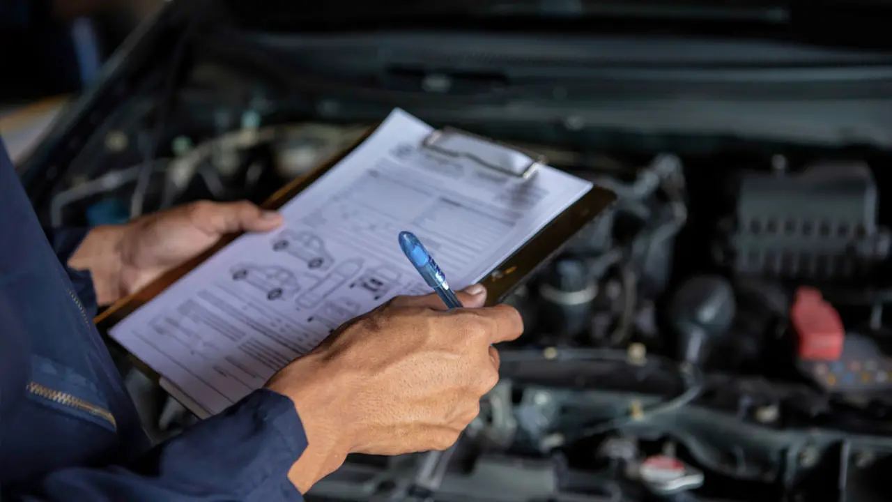 Mec&agrave;nic revisant els frens del cotxe