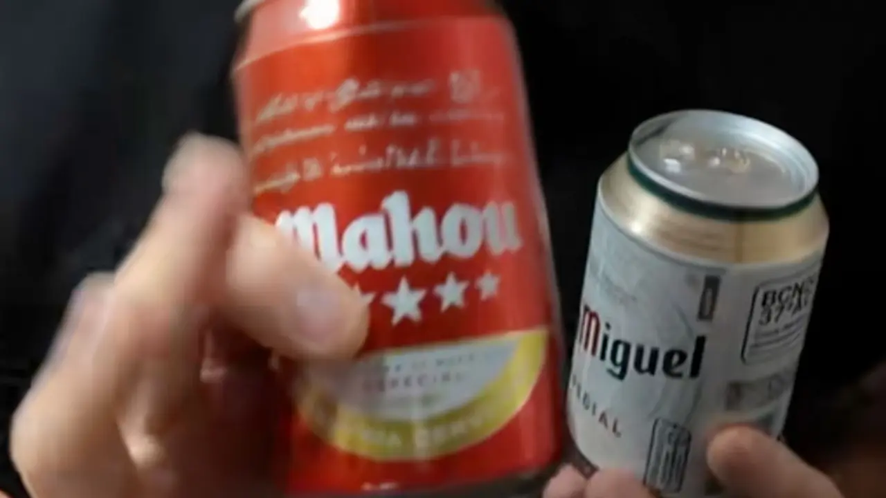 Llaunes de cervesa Mahou verdes i roges sobre una taula de bar. Tiktok @cervecero_miguel