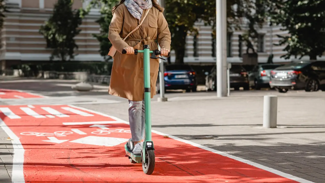 Usu&agrave;ria amb patinet el&egrave;ctric circulant per un carril bici a Barcelona