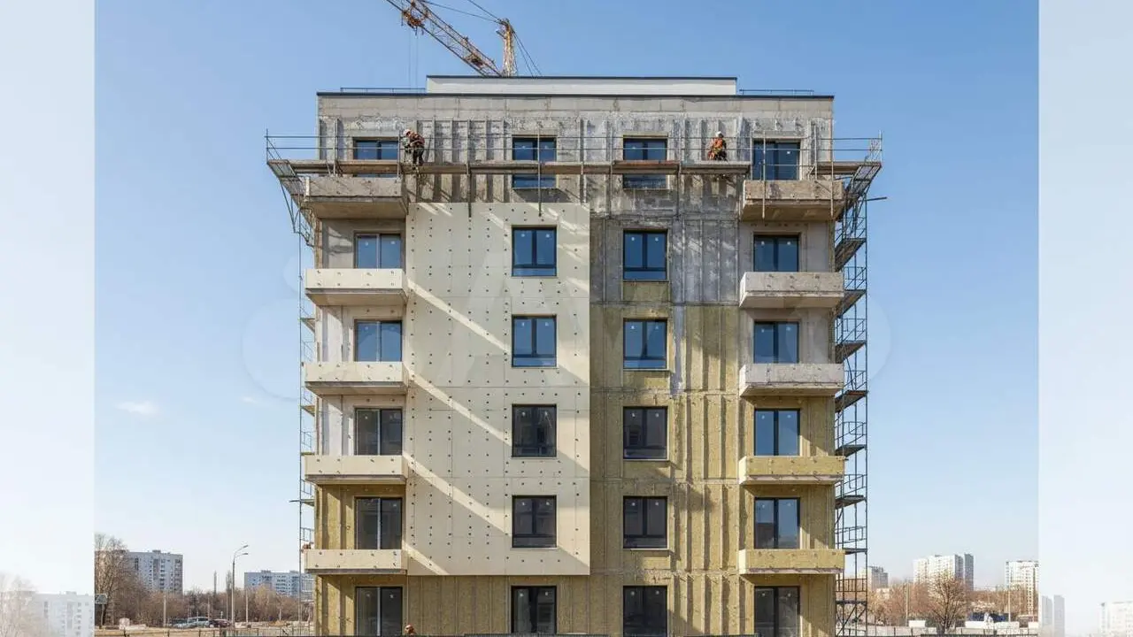 Fa&ccedil;ana d'edifici residencial amb a&iuml;llament t&egrave;rmic exterior sota un cel blau clar