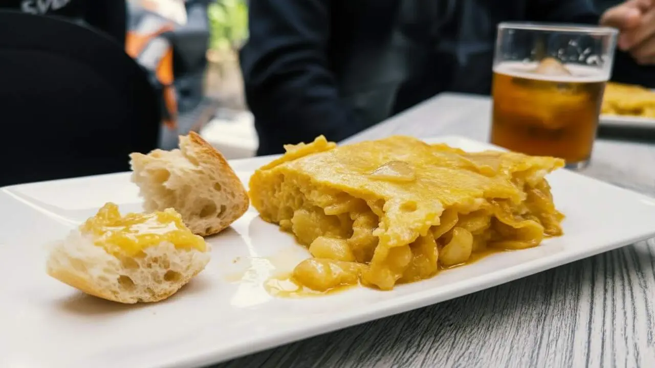 Retrat de Daniel P&eacute;rez G. analitzant la recepta de la tortilla de patata poc feta en un ambient gastron&ograve;mic acollidor &mdash; Imagen generada por IA