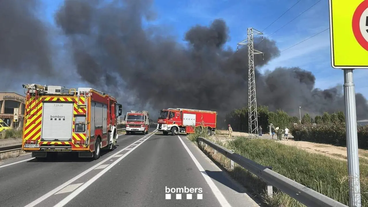 Bombers actuant en un incendi a l'exterior d'una nau amb contenidors de runa cremant a Deltebre &mdash; Imagen de la Fuente