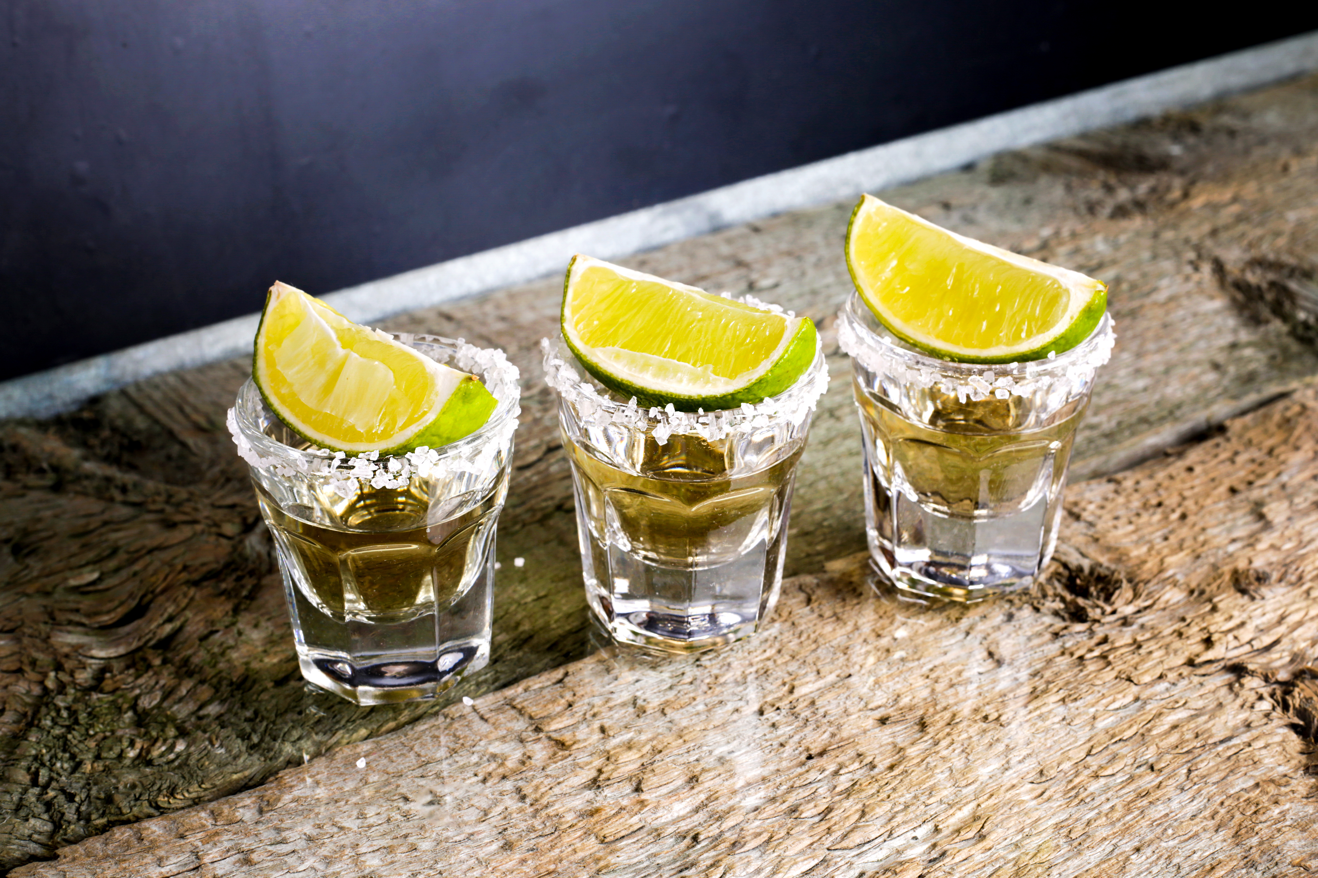 Glasses of silver and gold tequila with lime in a bar